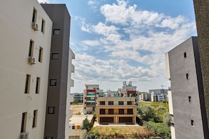 A modern multi-story residential building with balconies, a parking area, and a clear sky with clouds. - Apartamente Tomis Villa (Navodari)