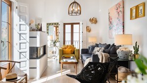 Ein modernes Wohnzimmer mit einer Couch, Sesseln, einem Couchtisch und einem Essbereich.