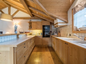 Una cocina con armarios de madera, una encimera, un fregadero y una estufa.