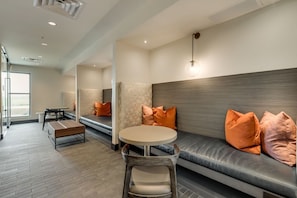 A modern lounge area with a sofa, a round table, and a bench.