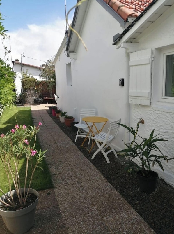 outdoor space with a gravel pathway, seating area, and potted plants.