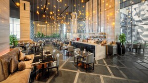 A spacious hotel lobby with a bar area, seating arrangements, and large windows. - SUN & MOON, Riverside Hotel (Phnom Penh)