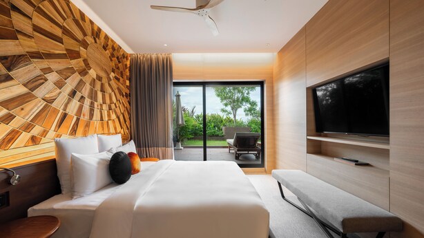 A modern hotel room with a large bed, a TV, a ceiling fan, and a view of the outdoors. - SUN & MOON, Riverside Hotel (Phnom Penh)