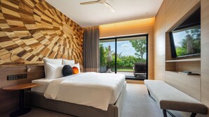 A modern hotel room with a large bed, a bench, a TV, and a view of greenery outside. - SUN & MOON, Riverside Hotel (Phnom Penh)