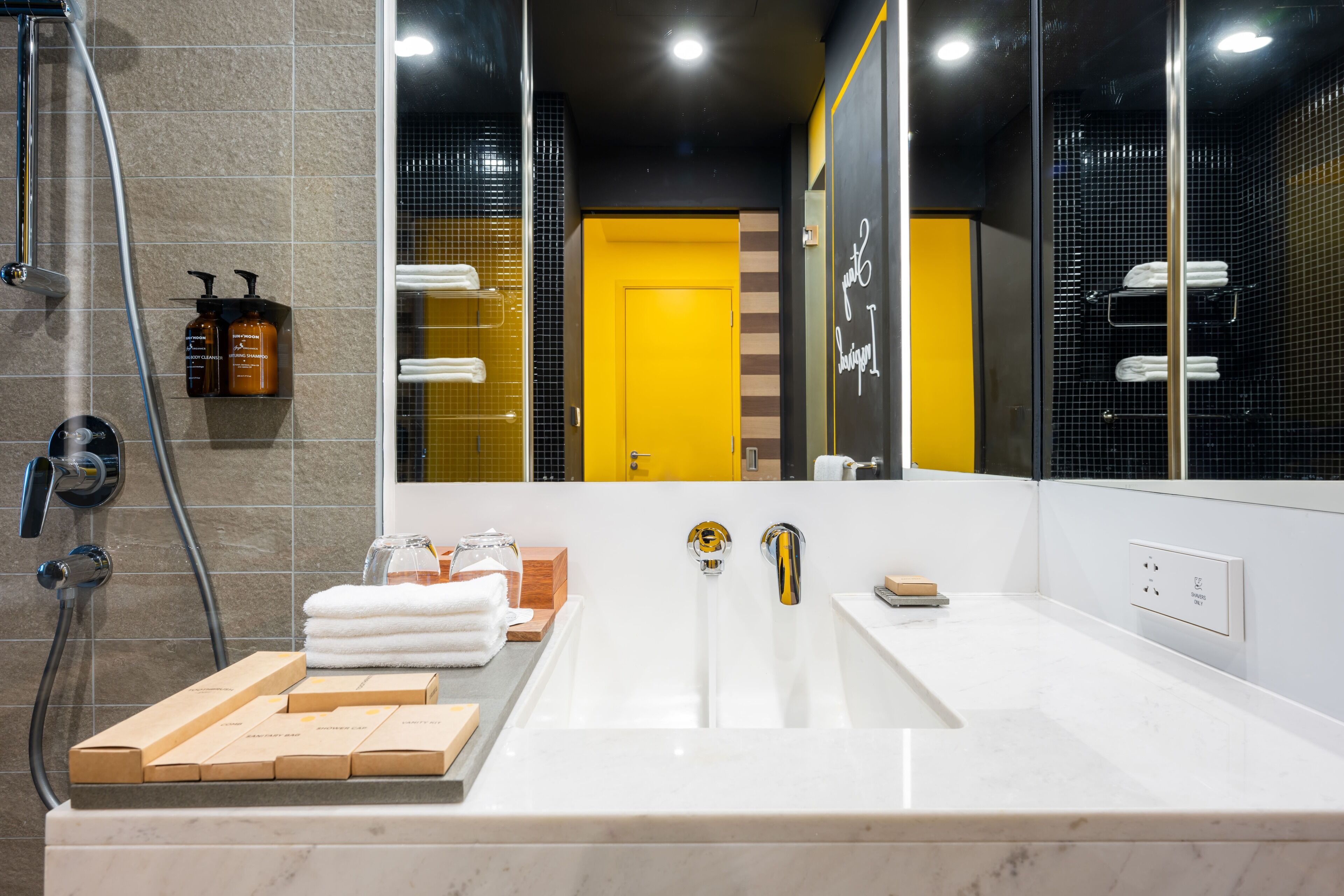 A modern bathroom with a large mirror, a bathtub, and a shower area.