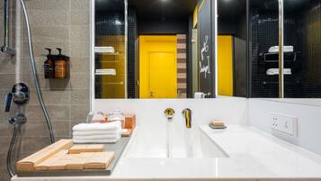 A modern bathroom with a large mirror, a bathtub, and a shower area.