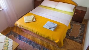 A bed with a yellow bedspread, two pillows, and two nightstands with red knobs. - Simo A1, Punat (Punat)