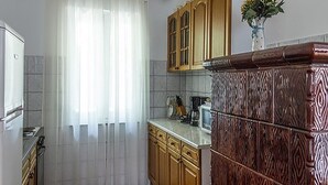A kitchen with wooden cabinets, a white countertop, and a stainless steel refrigerator. - Simo A1, Punat (Punat)