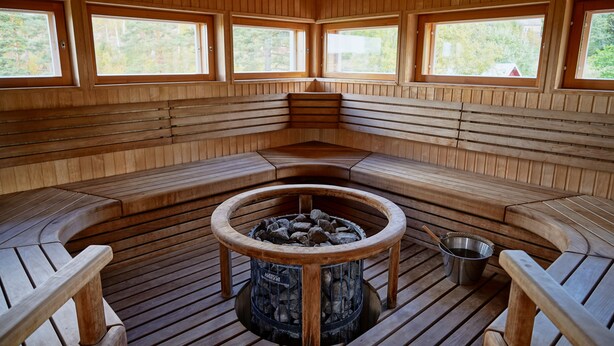 A sauna with wooden benches and a central fire pit. - Apartments in Porvoo (Porvoo)