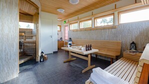 A wooden interior with a bench, table, and a sauna area. - Apartments in Porvoo (Porvoo)