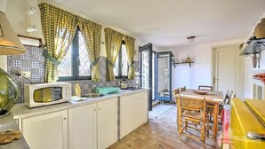 A kitchen with a microwave, sink, and wooden dining table.