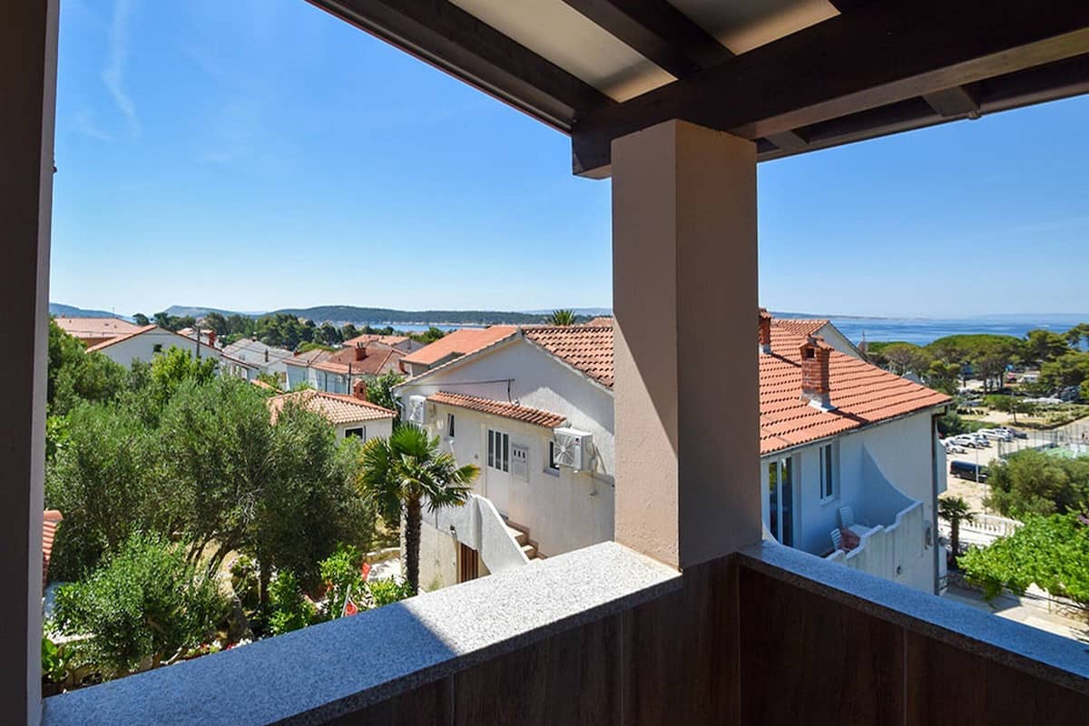 A balcony with a view of terraced houses and a clear blue sky.