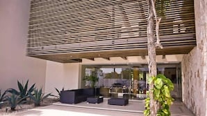 Un bâtiment moderne doté d’un toit à lattes, d’une terrasse et d’un arbre.