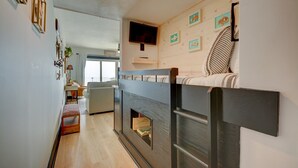 Une chambre confortable avec un lit superposé, une télévision et une fenêtre donnant sur un beau paysage.