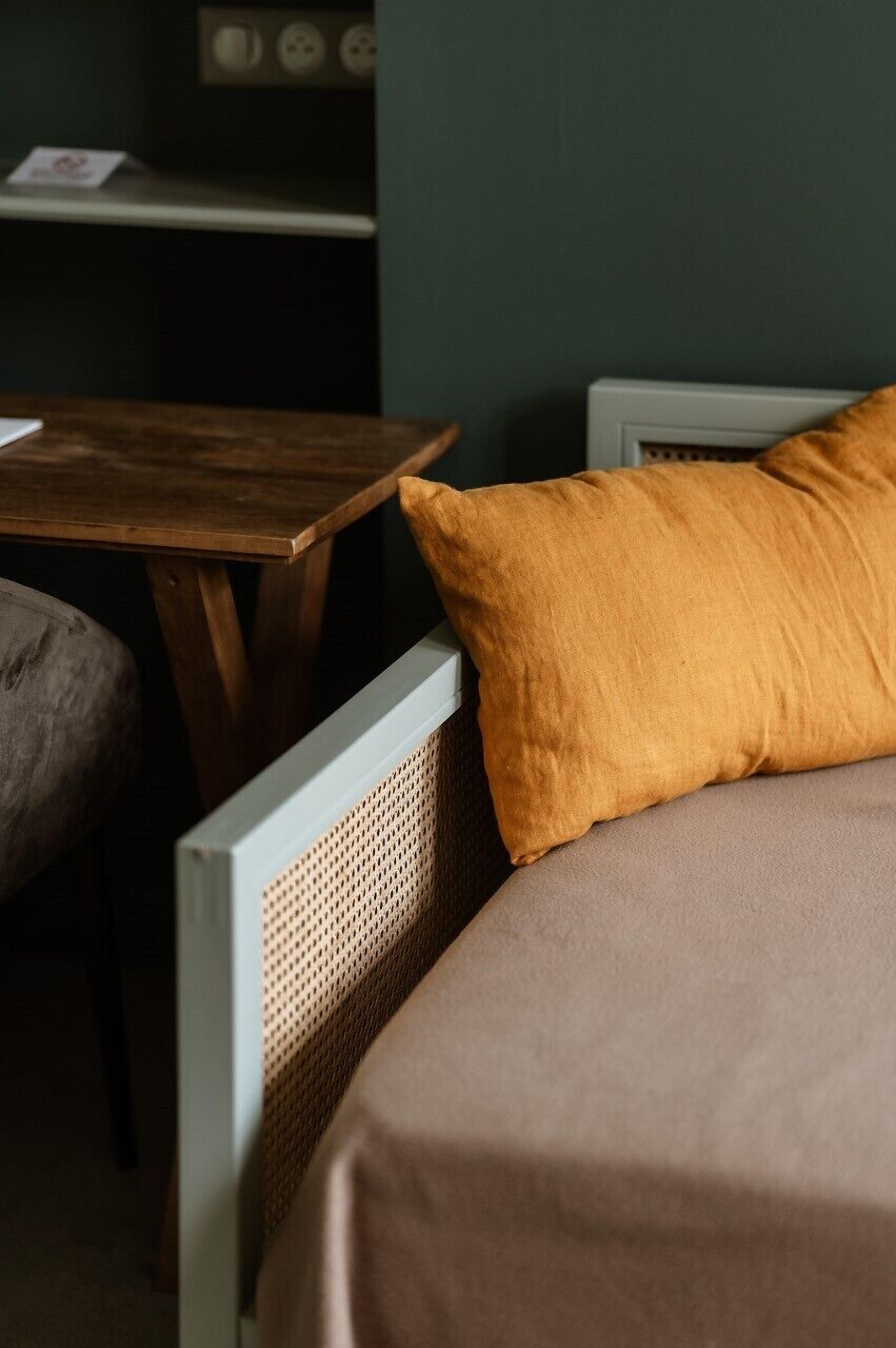 A room with a bed, a wooden table, and a chair.
