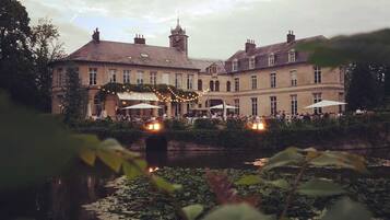 A historic building with a courtyard and a pond.