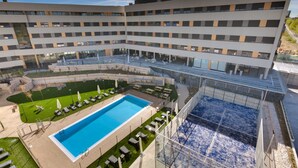 Un hôtel moderne doté d’une piscine sur le toit, de plusieurs étages et d’une cour aménagée.