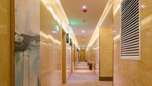 A hotel corridor with a marble floor, wall-mounted artwork, and a ceiling with recessed lighting. - Greentree Inn Taian High Speed Railway Station Lingshan Street (Tai'an)