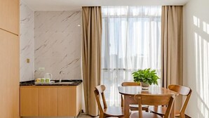 A modern kitchen with a marble backsplash, wooden cabinets, and a dining area with a table and chairs. - Greentree Inn Taian High Speed Railway Station Lingshan Street (Tai'an)