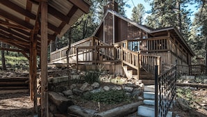 A wooden cabin with a wooden staircase leading to a deck. - Rock'inn Pines by Ruidoso Vacation Rentals (Ruidoso)