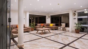 A spacious lobby with a marble floor, a central coffee table, sofas, and potted plants. - West Lerruat Hotel (Nairobi)