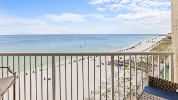 A balcony with a view of a beach and ocean.