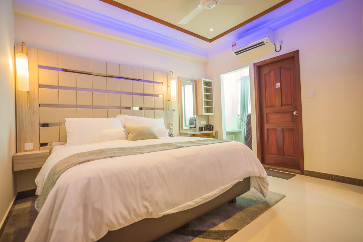 Deluxe Triple Room | Minibar, in-room safe, desk, iron/ironing board