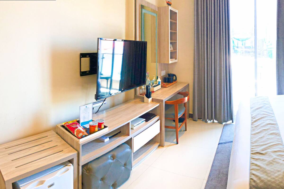 Deluxe Room, Balcony | Minibar, in-room safe, desk, iron/ironing board