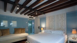 Une chambre à coucher avec un lit, un canapé et une table de chevet avec une lampe.