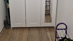 Une armoire blanche à deux portes et dotée d’un miroir.
