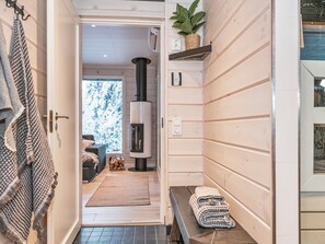 A wooden interior with a fireplace, a bench, and a plant. - Rukan rinnemaa a by Interhome (Kuusamo)