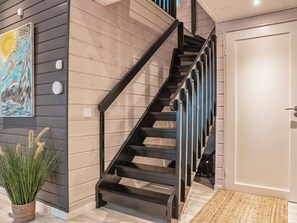 A staircase with black railings leading to a landing, a door on the right, and a potted plant on the left. - Rukan rinnemaa a by Interhome (Kuusamo)