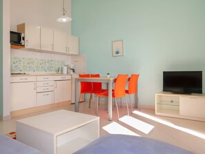 A compact living space with a kitchenette, dining area, and a TV. - Apartment Ivana by Interhome (Senj)