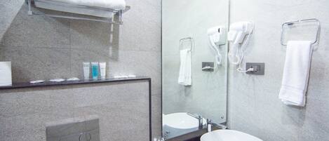 A modern bathroom with a large mirror, a sink, and a towel rack.