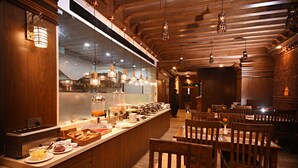 A restaurant with wooden interiors, a buffet counter, and hanging pendant lights. - Everest Boutique Hotel - Your Heritage Home (Kathmandu)