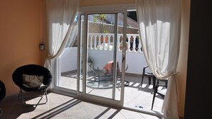 A room with a sliding glass door leading to a patio, a ceiling fan, and a chair. - Villa with Private Pool, Terrace, A/C and Wi-Fi (San Miguel de Salinas)