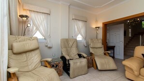 A room with three beige reclining chairs, a small table with a glass top, and a pair of floor lamps. - Pet-Friendly Villa Encantada with Sea View & Pool (Arona)