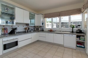 A kitchen with white cabinets, a built-in oven, a microwave, and a dishwasher. - Pet-Friendly Villa Encantada with Sea View & Pool (Arona)