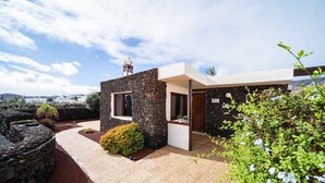 Un edifici modern amb façana de pedra, una finestra petita i una porta.
