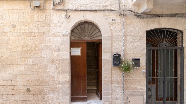 Un edificio in pietra con una porta di legno e un cancello in metallo.