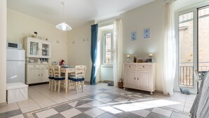 Una cucina con tavolo, sedie, pensili e frigorifero.
