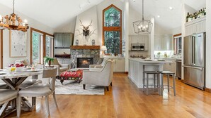 A spacious kitchen with a stone fireplace, wooden beams, and a large island.