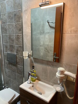 Habitación económica | Baño | Regadera, regadera tipo lluvia, secadora de cabello, pantuflas
