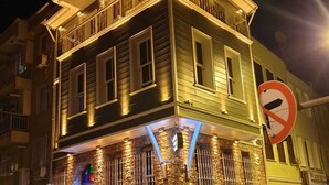 Un immeuble à plusieurs étages, doté d’un balcon au deuxième étage, d’un panneau indiquant qu’il est interdit de se garer et d’un lampadaire.