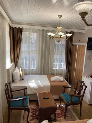 Habitación triple Deluxe | Área de sala de estar | Televisión LED de 40 pulgadas con canales por cable y televisión