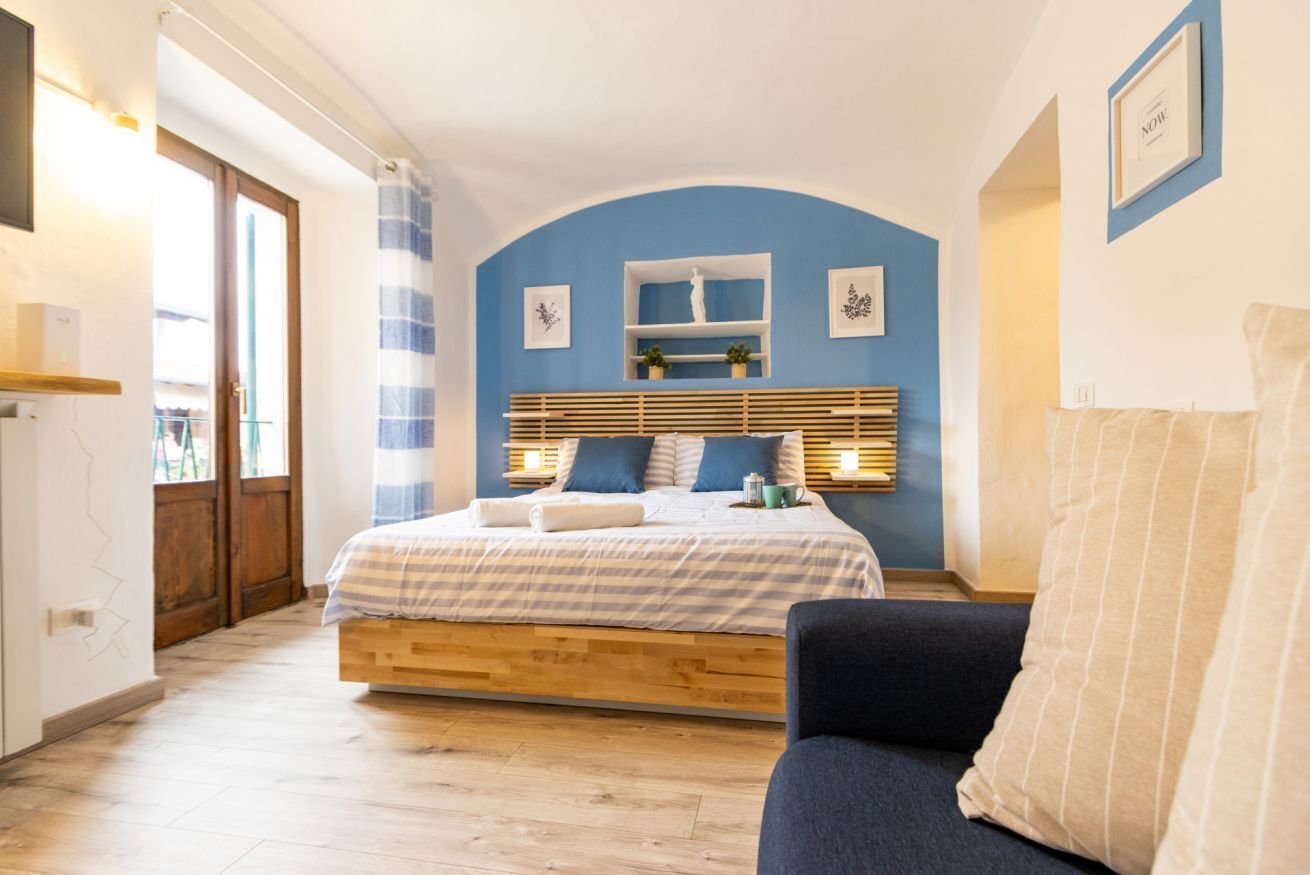 A bedroom with a bed, bedside tables, a window, and a door.