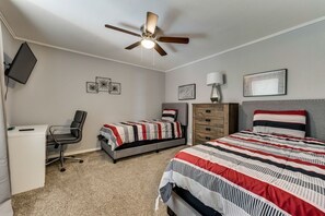 A bedroom with a bed, a desk, a chair, a dresser, and a ceiling fan. - GP56A | G. Prairie Escape | 4BD | Pool | Workspace (Grand Prairie)