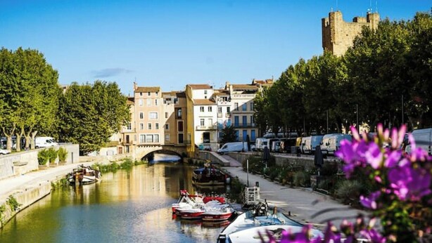A canal with boats, a bridge, and buildings along the riverbank. - Chez Nicolle et Jean - House near Narbonne (Canet)