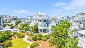 A coastal residential area with multiple houses featuring prominent balconies and large windows, likely offering ocean views. - Dune Lake Escape with Pool and Elevator (Santa Rosa Beach)