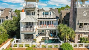 A large, multi-story house with a prominent tower, a swimming pool, and a covered patio area. - Dune Lake Escape with Pool and Elevator (Santa Rosa Beach)